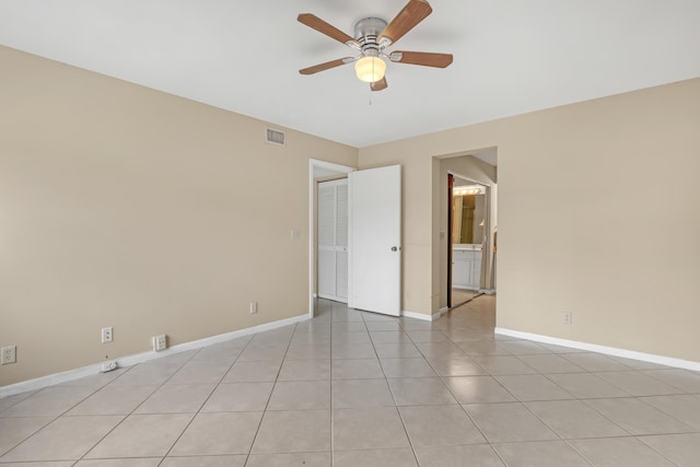 empty room with ceiling fan and light tile patterned flooring