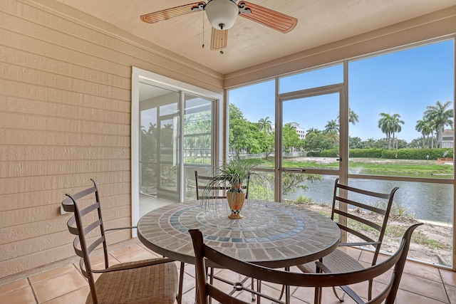 sunroom with ceiling fan, a water view, and plenty of natural light