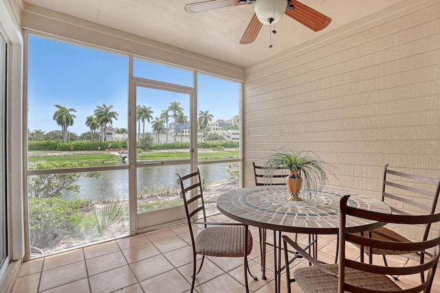 sunroom / solarium with a water view and ceiling fan