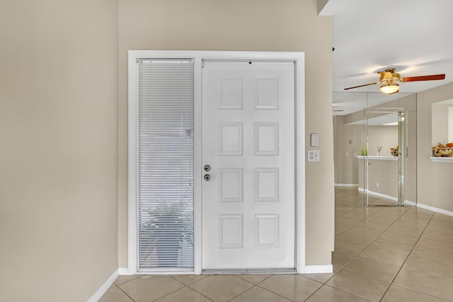 tiled entryway featuring ceiling fan