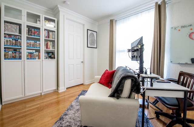 interior space featuring light wood-type flooring and ornamental molding