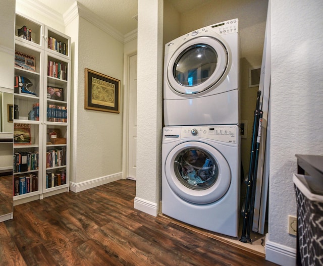 laundry area with crown molding, stacked washing maching and dryer, and dark wood-type flooring