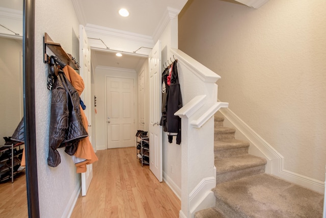 hall with light wood-type flooring and crown molding