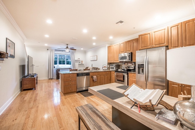 kitchen with backsplash, light hardwood / wood-style flooring, ceiling fan, appliances with stainless steel finishes, and kitchen peninsula