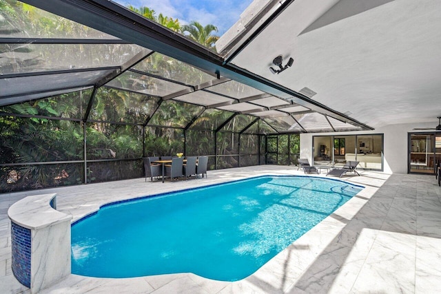 pool with glass enclosure and a patio