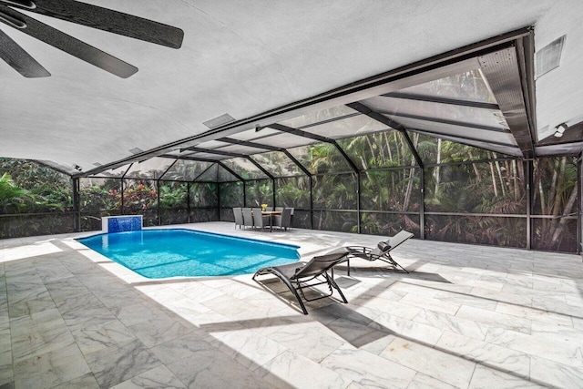 view of pool featuring pool water feature, glass enclosure, and a patio area