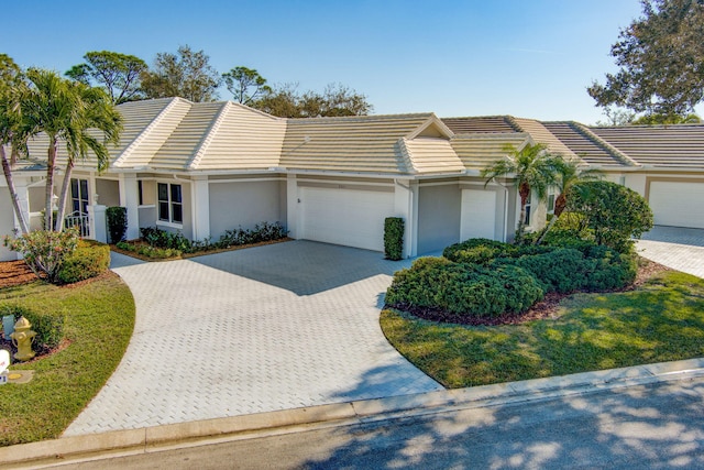 ranch-style house with a garage and a front lawn