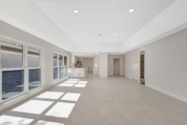 unfurnished living room featuring a tray ceiling