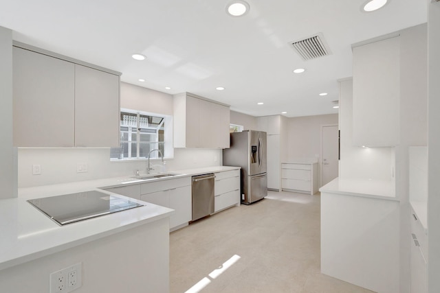 kitchen featuring appliances with stainless steel finishes, sink, and white cabinets