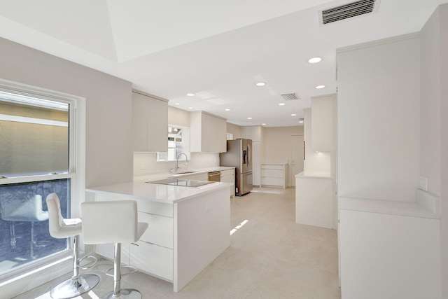 kitchen featuring white cabinetry, sink, stainless steel appliances, and kitchen peninsula