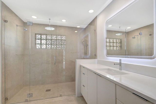 bathroom with vanity, plenty of natural light, and a shower with shower door