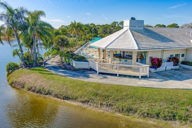 back of property with a yard and a water view