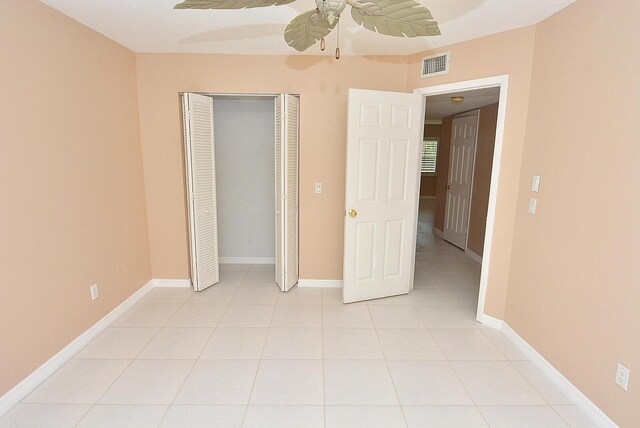 1225 NW 21st St Unit 3406, Stuart, FL 34994 - unfurnished bedroom featuring light tile patterned flooring, a closet, a ceiling fan, and baseboards