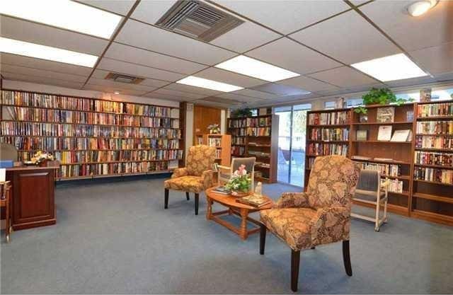 1225 NW 21st St Unit 3406, Stuart, FL 34994 - sitting room with wall of books, a drop ceiling, and carpet