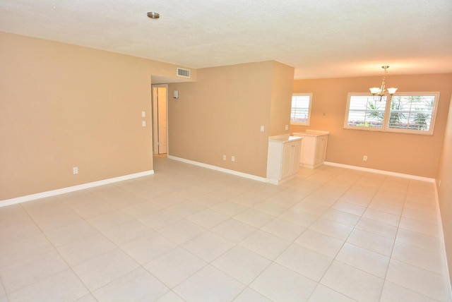 1225 NW 21st St Unit 3406, Stuart, FL 34994 - spare room featuring a chandelier, baseboards, and a textured ceiling
