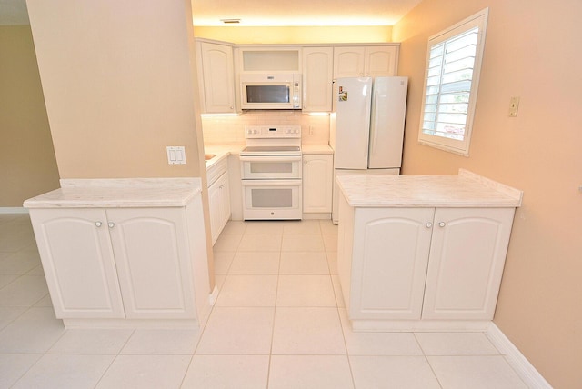 1225 NW 21st St Unit 3406, Stuart, FL 34994 - kitchen featuring white appliances, a peninsula, tasteful backsplash, light countertops, and light tile patterned floors