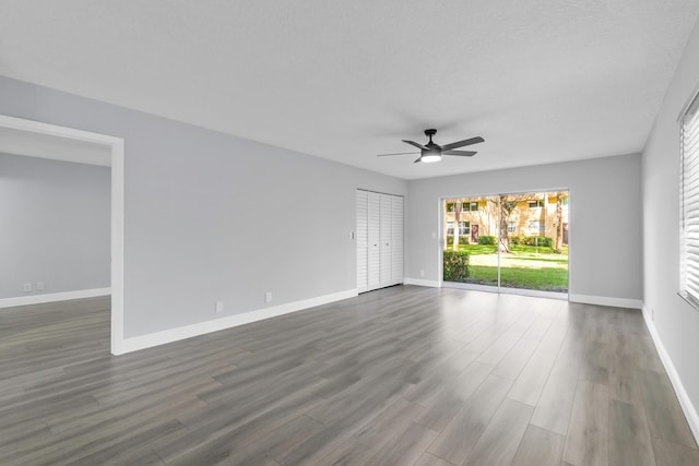 empty room with dark hardwood / wood-style flooring and ceiling fan