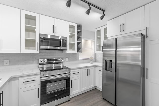 kitchen with white cabinetry, a textured ceiling, and appliances with stainless steel finishes