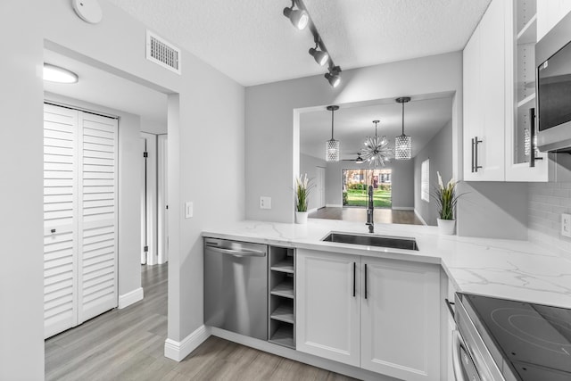 kitchen featuring sink, white cabinets, a chandelier, and appliances with stainless steel finishes