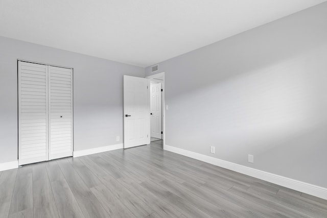 unfurnished bedroom with light hardwood / wood-style floors and a closet