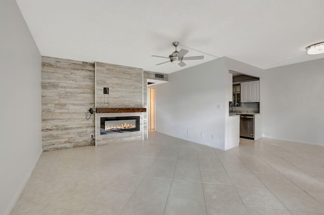 unfurnished living room featuring a tile fireplace, ceiling fan, and light tile patterned floors