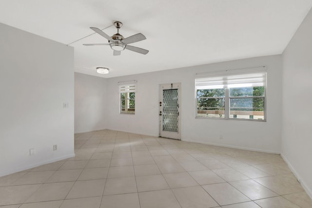 unfurnished room with light tile patterned floors, plenty of natural light, and ceiling fan