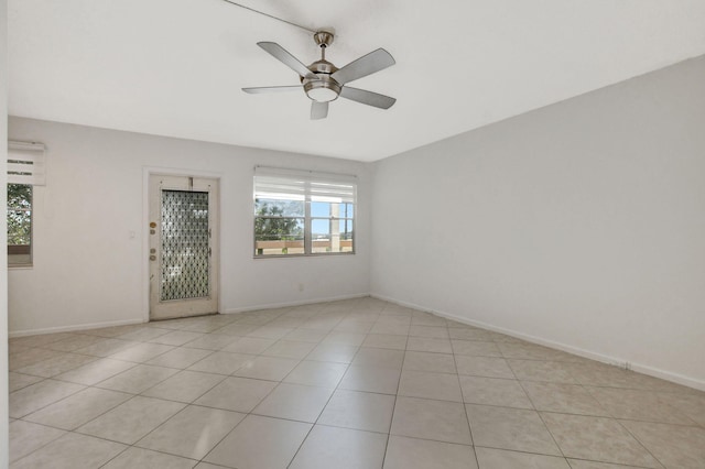 tiled spare room with ceiling fan