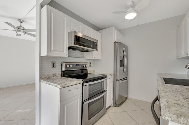 kitchen featuring appliances with stainless steel finishes, backsplash, ceiling fan, light tile patterned floors, and white cabinetry