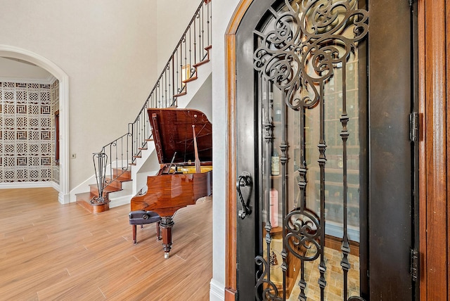 foyer entrance with a towering ceiling and light wood-type flooring