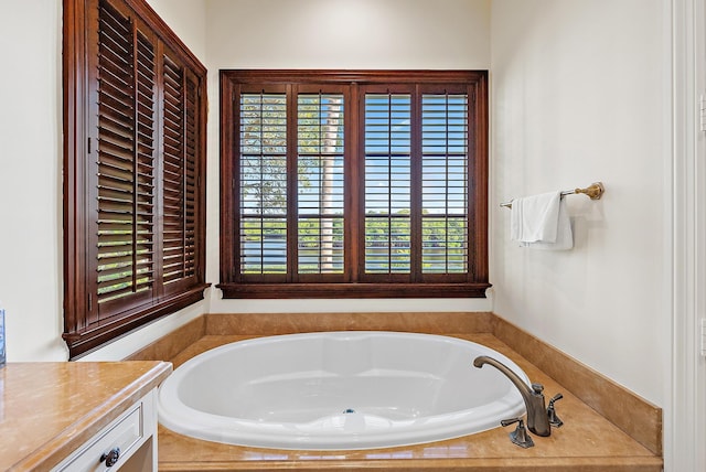 bathroom with vanity and tiled bath