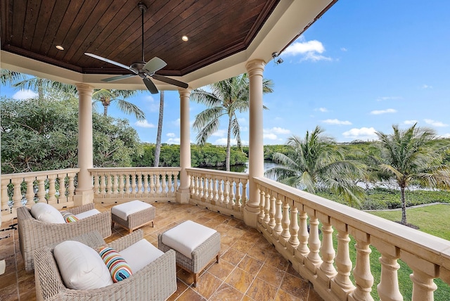 view of patio / terrace featuring a water view, a balcony, and ceiling fan