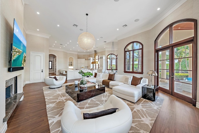 living room featuring a premium fireplace, crown molding, and light hardwood / wood-style floors