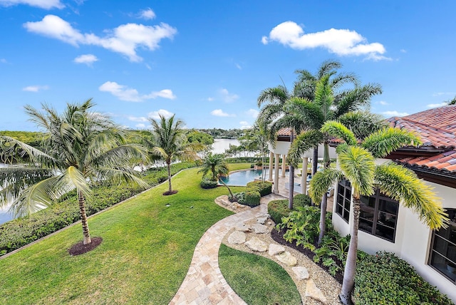 view of home's community featuring a pool, a water view, a patio area, and a lawn