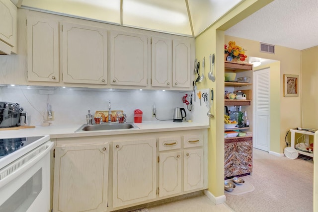 kitchen with sink, backsplash, light carpet, and white range with electric cooktop