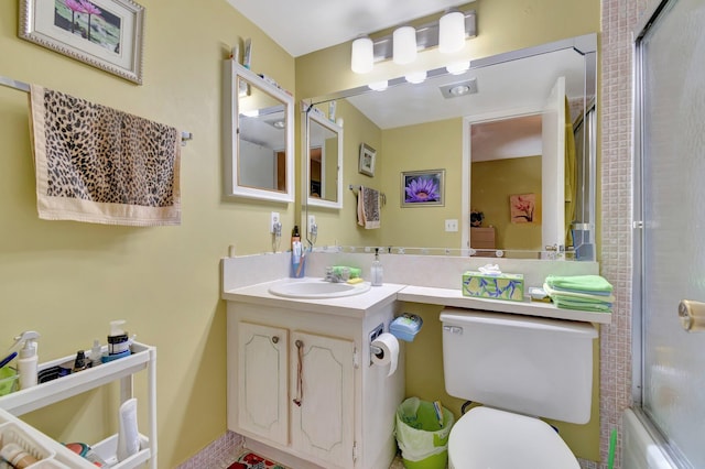 full bathroom featuring toilet, vanity, and bath / shower combo with glass door