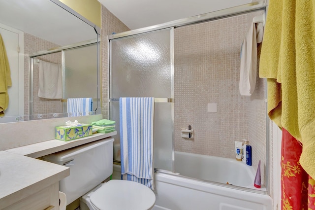 full bathroom featuring toilet, enclosed tub / shower combo, and vanity