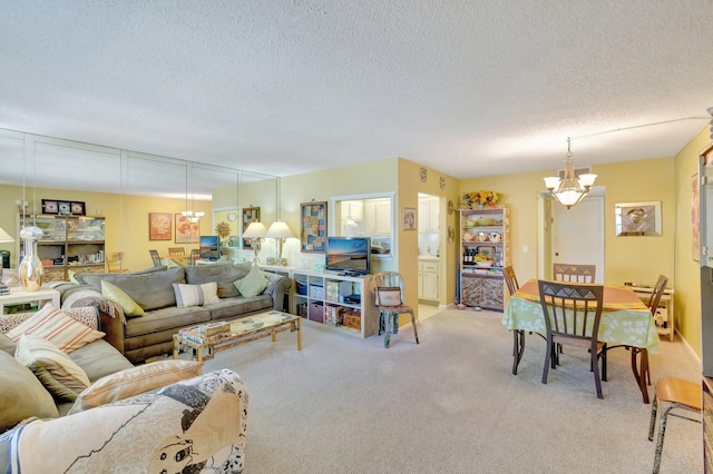 carpeted living room featuring a textured ceiling and a notable chandelier