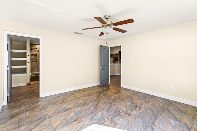 unfurnished bedroom with a spacious closet and ceiling fan