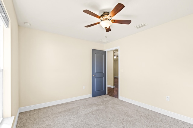 carpeted spare room with ceiling fan