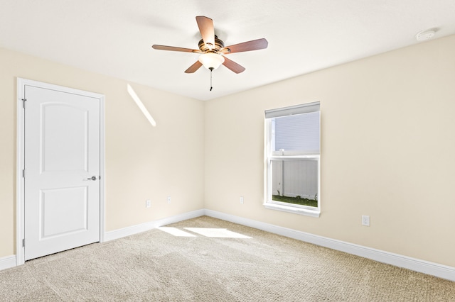 carpeted spare room with ceiling fan