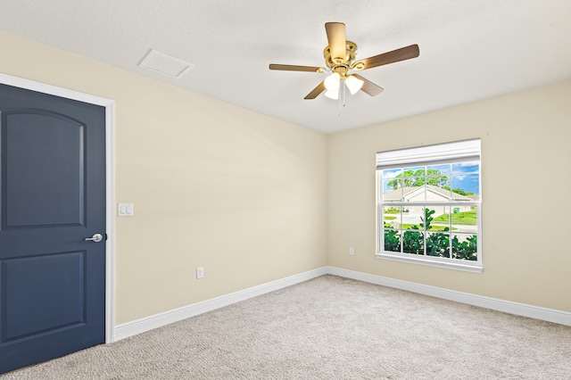 carpeted spare room featuring ceiling fan