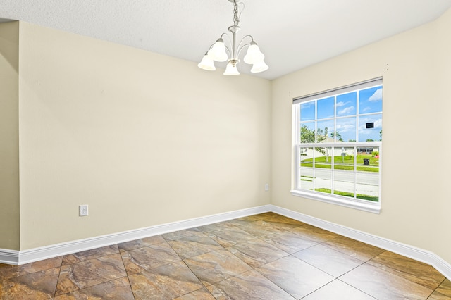 unfurnished room featuring plenty of natural light and a chandelier