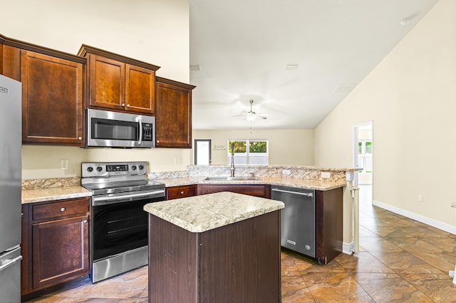 kitchen featuring a center island, stainless steel appliances, ceiling fan, and sink