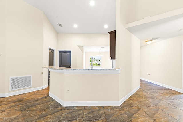 kitchen with a notable chandelier and light stone counters