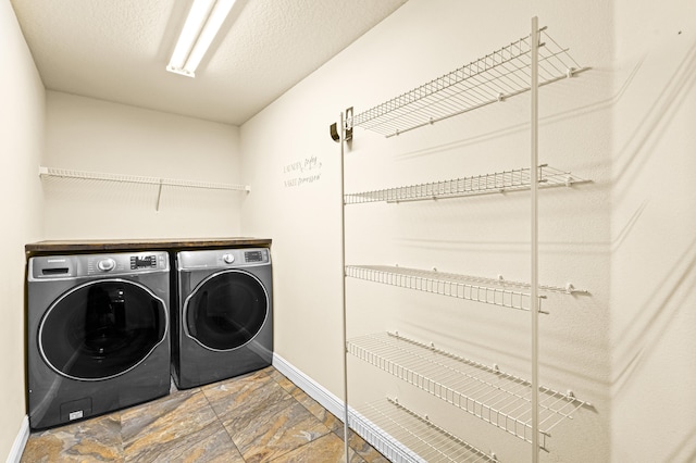 laundry room featuring washing machine and dryer and a textured ceiling