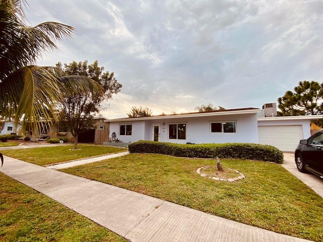 ranch-style house featuring a front yard and a garage