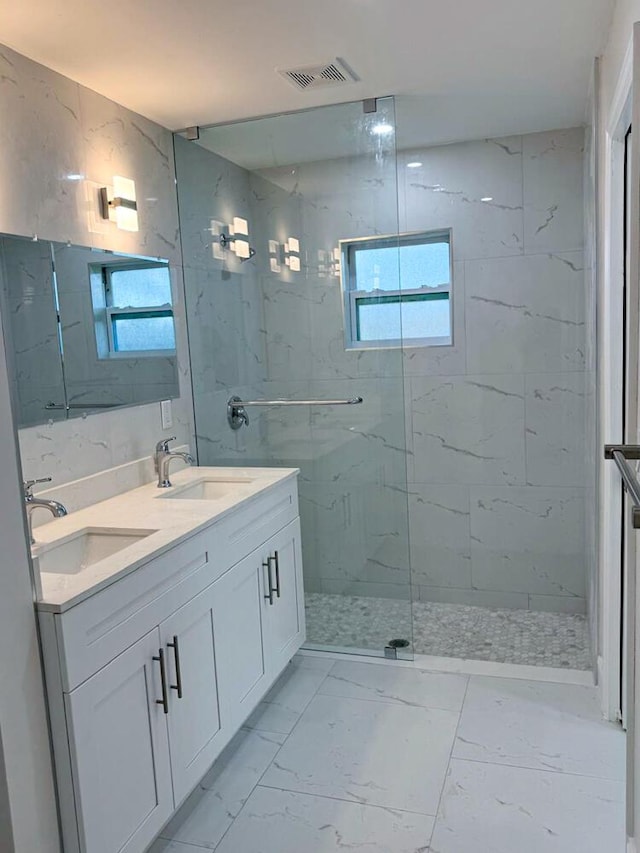 bathroom with vanity and a tile shower