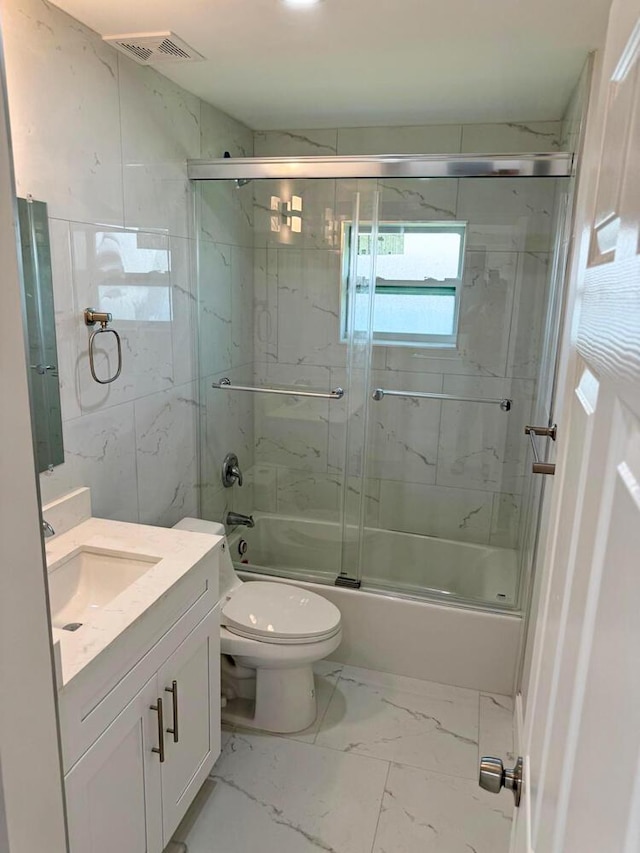 full bathroom featuring vanity, enclosed tub / shower combo, and toilet