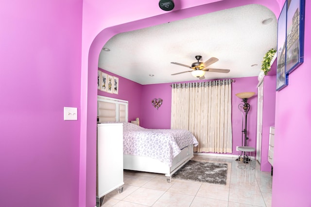 bedroom with light tile patterned floors, a textured ceiling, and ceiling fan