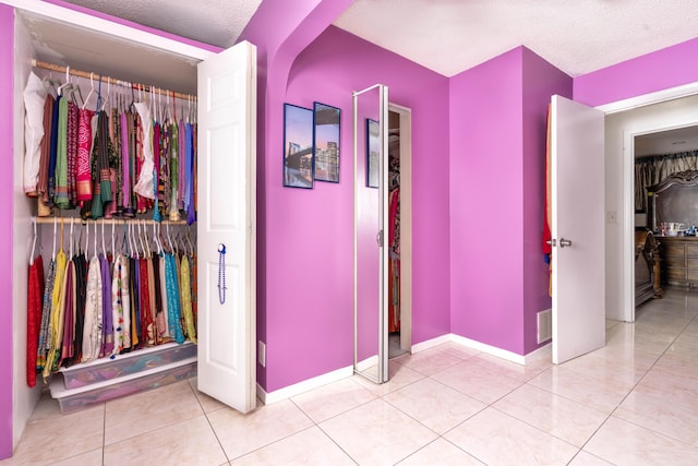 interior space with light tile patterned floors and a textured ceiling